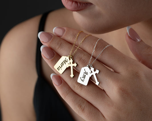 Personalized name cross necklaces held by model