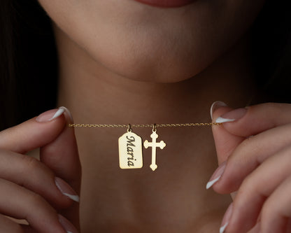 Gold personalized name cross necklace held by model