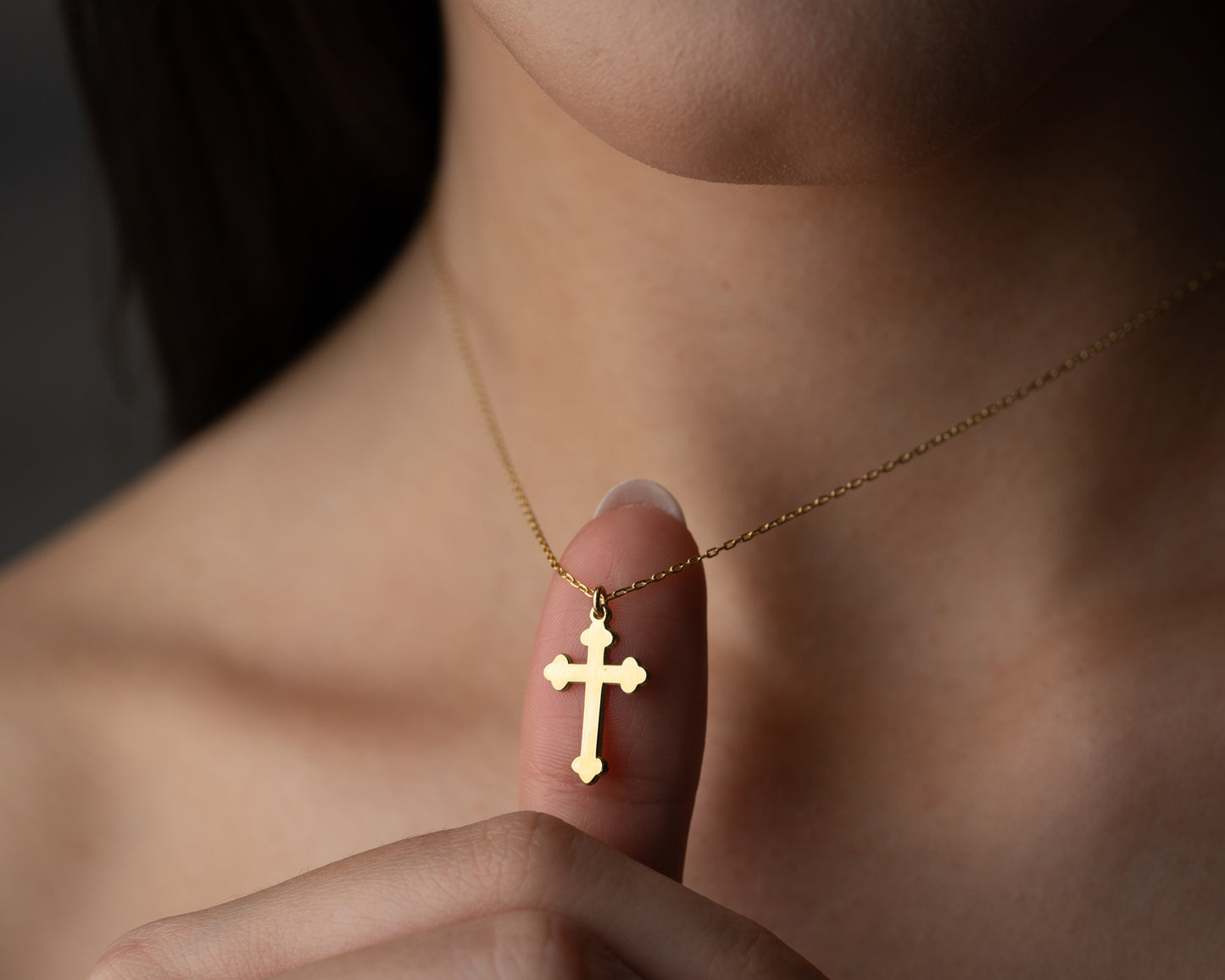 Gold trefoil cross pendant worn