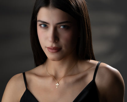 Gold trefoil cross necklace on model